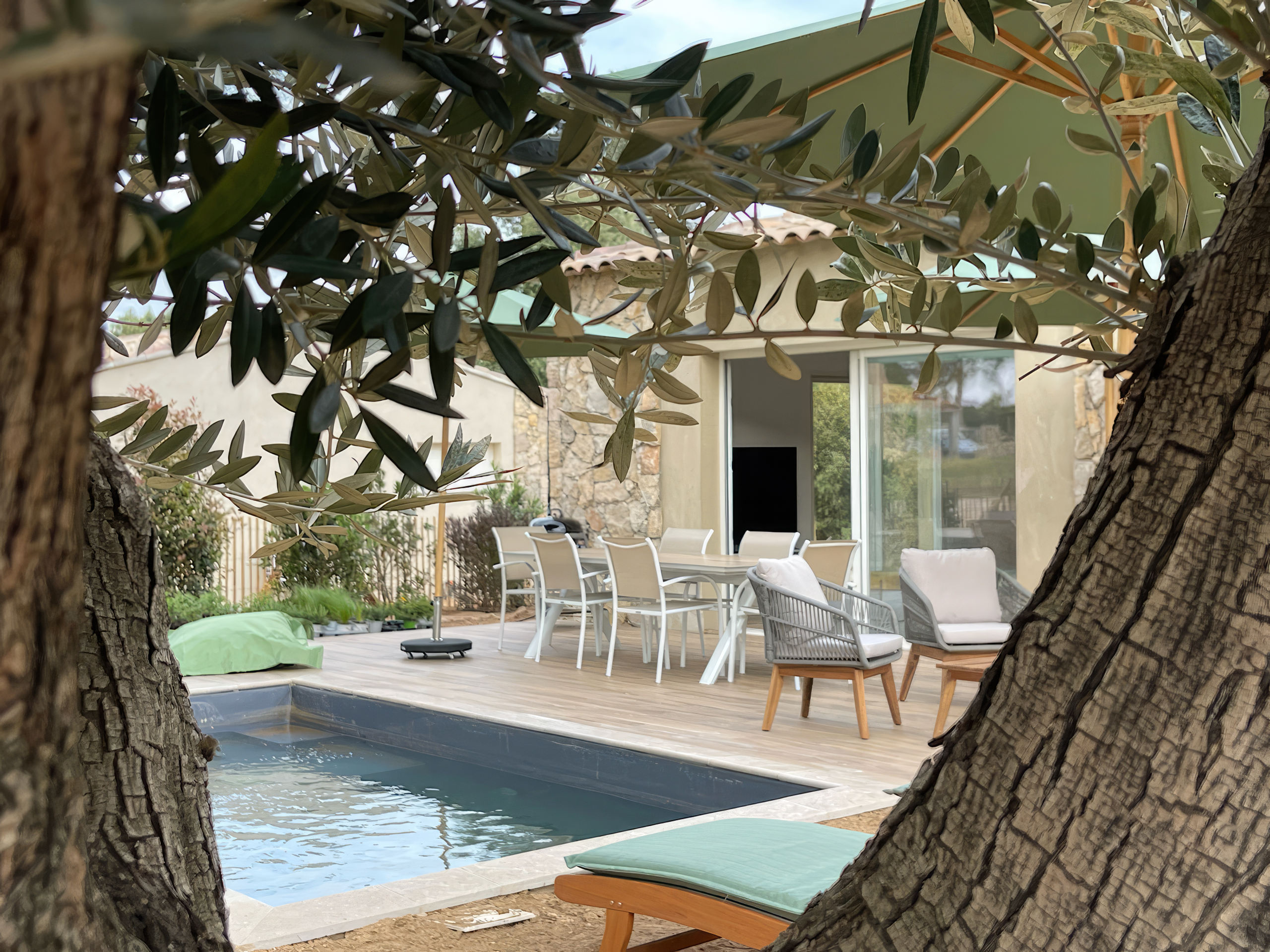 Grande terrasse et sa piscine avec une vue à couper le souffle sur la baie de Calvi. La terrasse offre des bains de soleil, une table à manger, un salon de jardin. Une vraie continuité avec la pièce de vie de la villa.