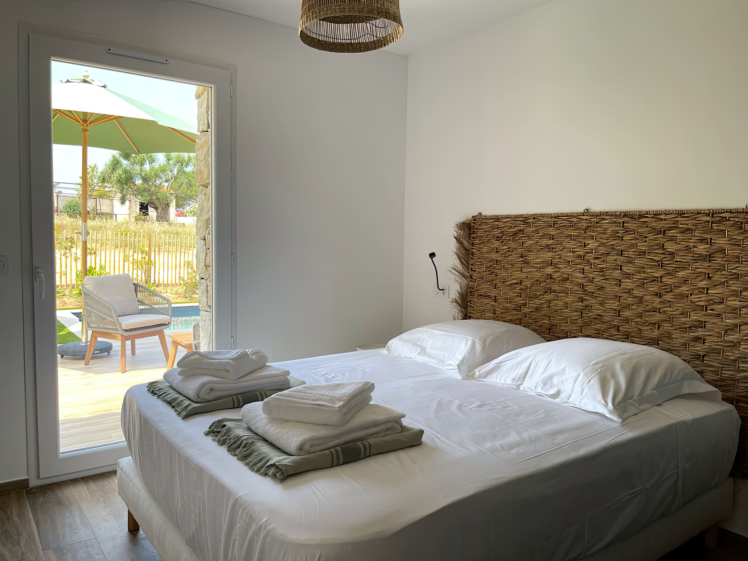 Chambre équipée d'un lit double 160 avec tables de chevet, lampes de lecture, grand placard de rangement et un accès à son balcon. La chambre offre également une vue complète sur la baie de Calvi.