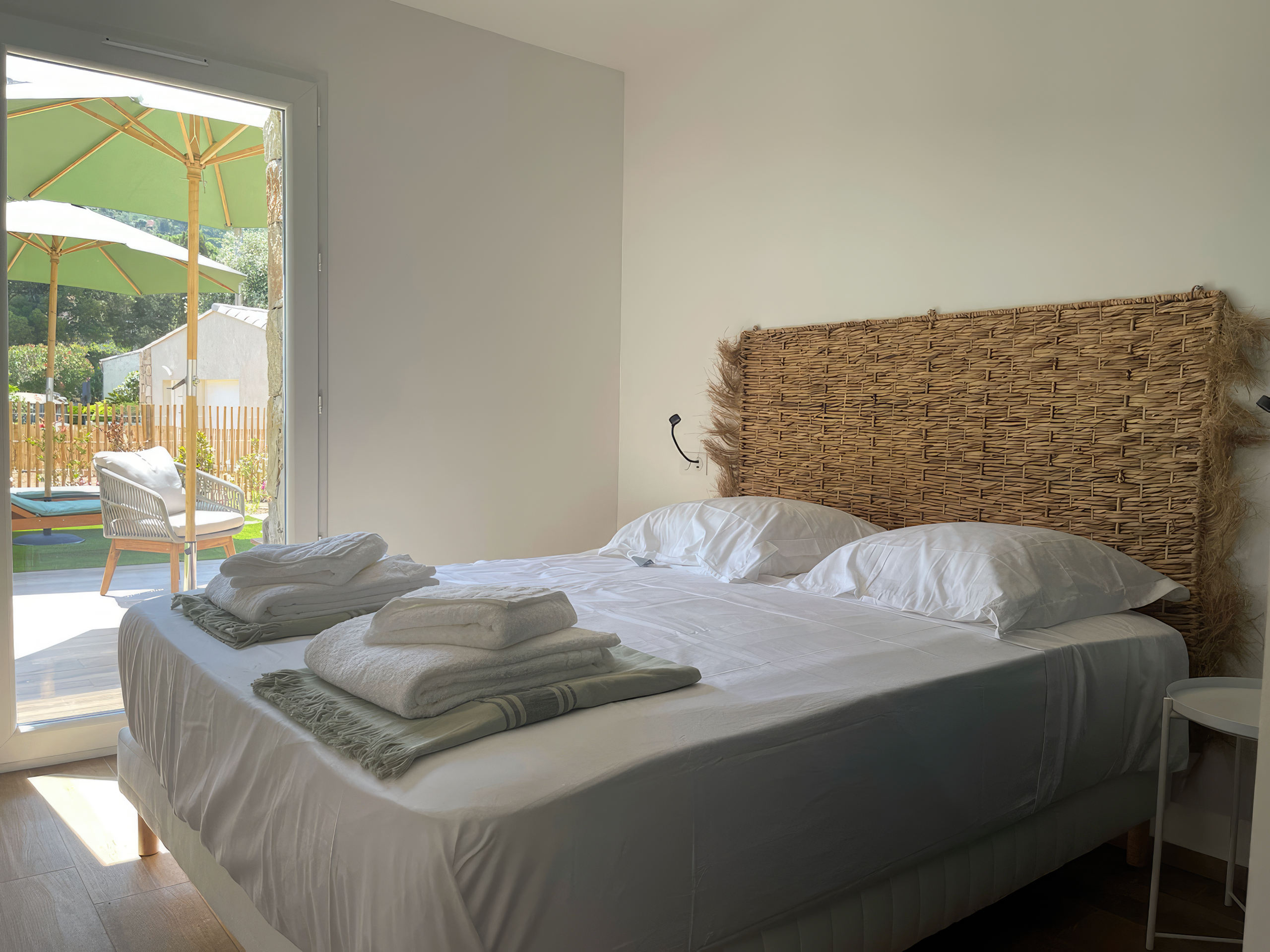 Chambre équipée d'un lit double 160 avec tables de chevet, lampes de lecture, grand placard de rangement et un accès à son balcon. La chambre offre également une vue complète sur la baie de Calvi.