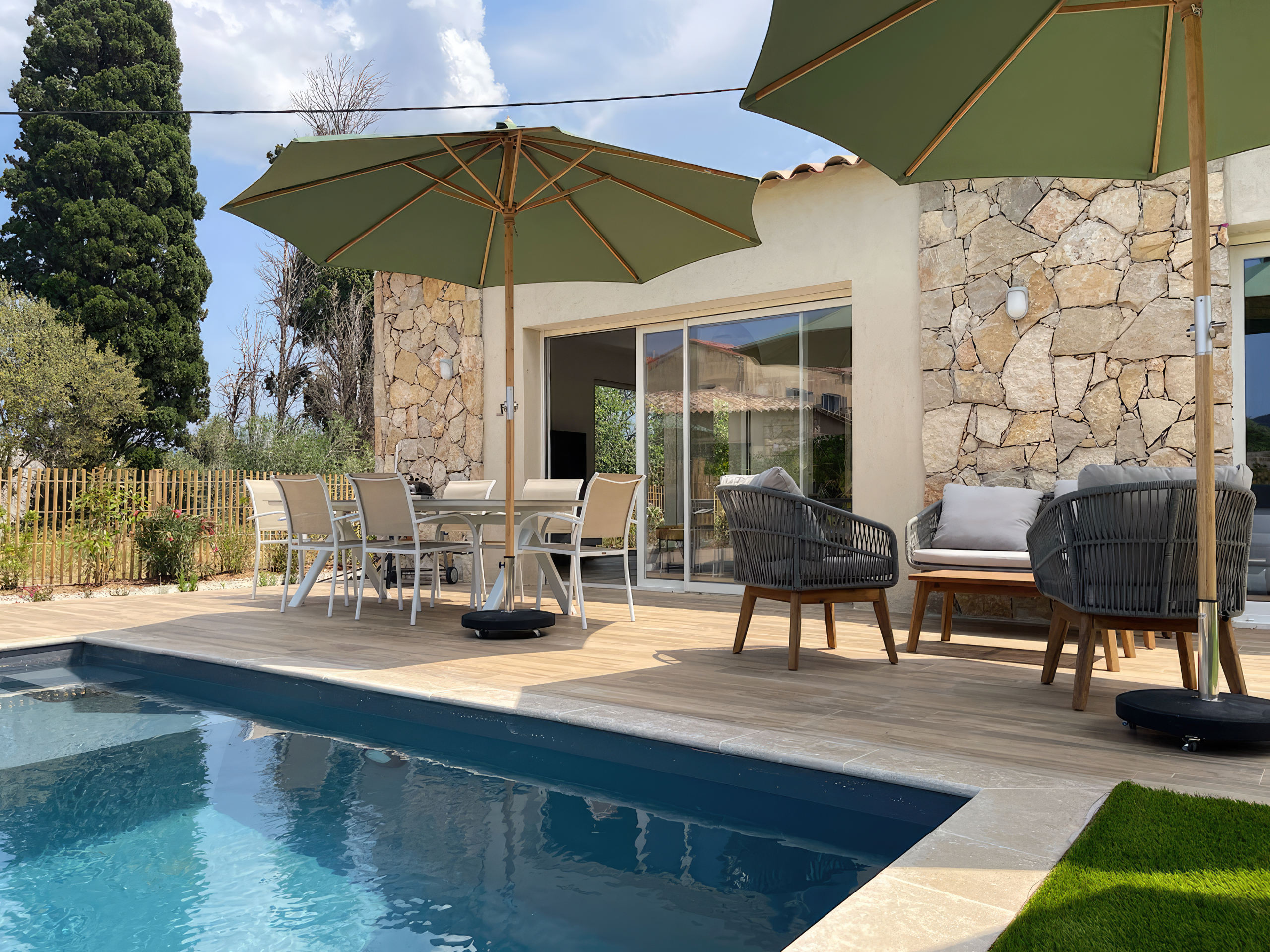 Grande terrasse et sa piscine avec une vue à couper le souffle sur la baie de Calvi. La terrasse offre des bains de soleil, une table à manger, un salon de jardin. Une vraie continuité avec la pièce de vie de la villa.